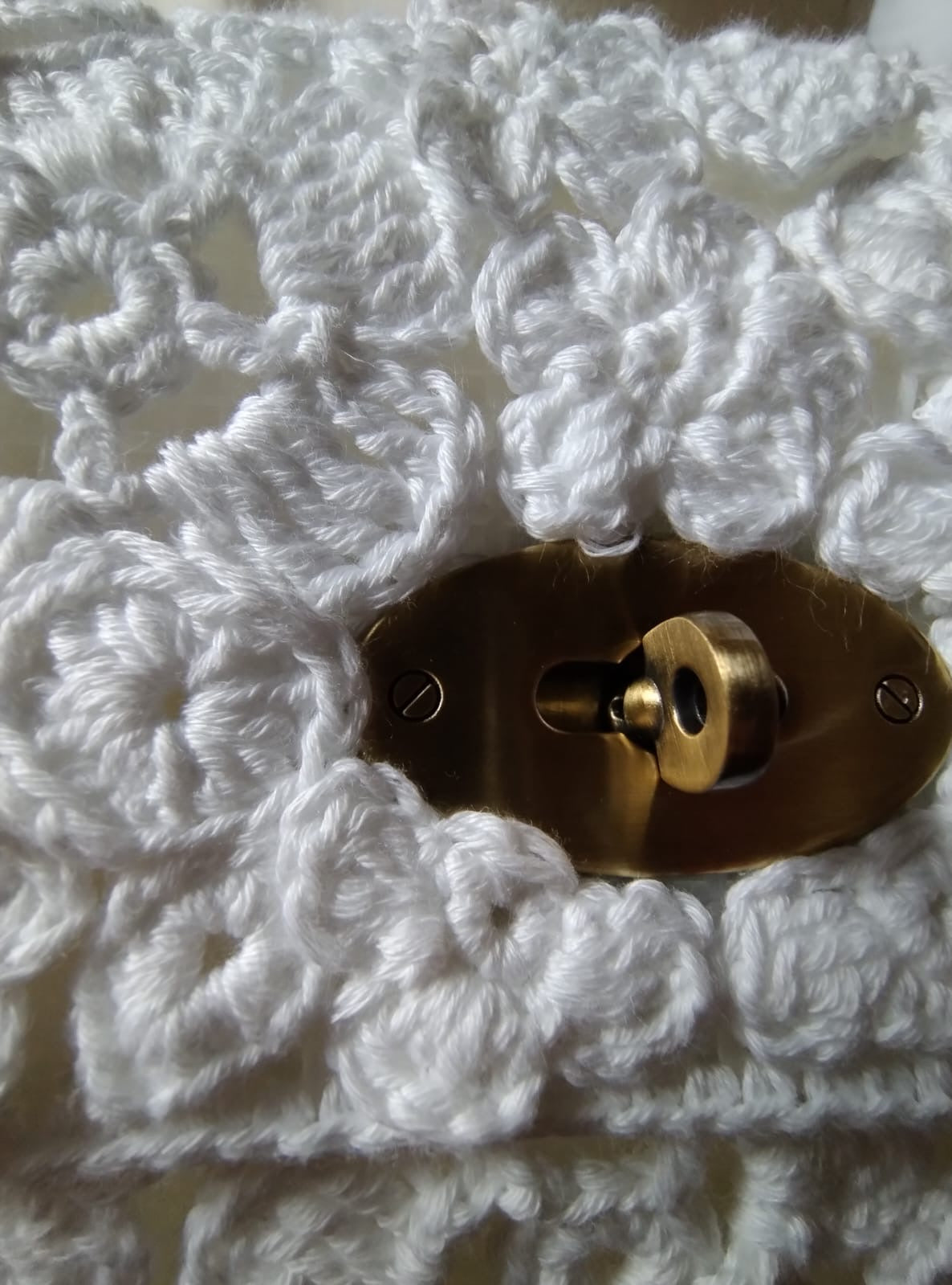 Scopri Fiorella la Borsa, realizzata a mano in cotone bianco all'uncinetto. Design elegante con fiori, chiusura in metallo e tracolla in cotone. Perfetta per ogni occasione!