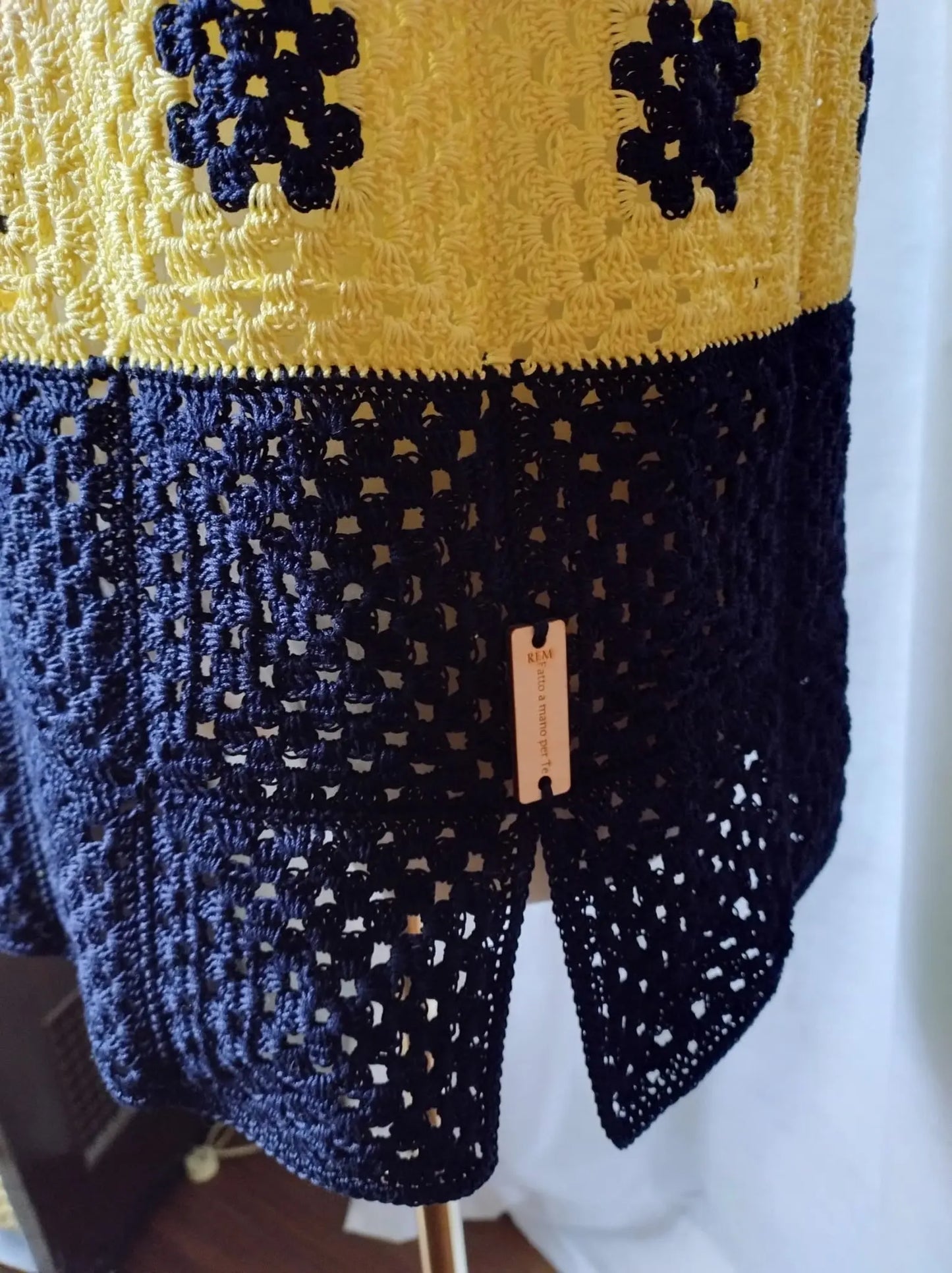 Scopri Iris la Canotta, realizzata in cotone con piastrella "Nonna" all'uncinetto. Ampia vestibilità, scollo quadrato e spacchi sui fianchi per un look estivo elegante. Acquista ora!