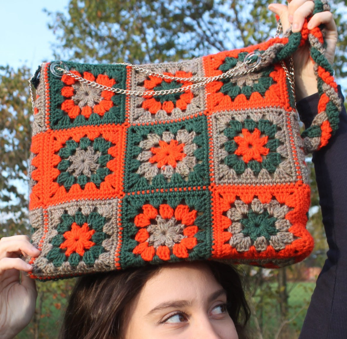 Illumina i tuoi giorni invernali con 'Vera', la nostra borsa in lana color rosso vermiglio, verdone e beige. Lavorata a mano all'uncinetto, misura 30cmX35cm, è un capolavoro di calore e colore.