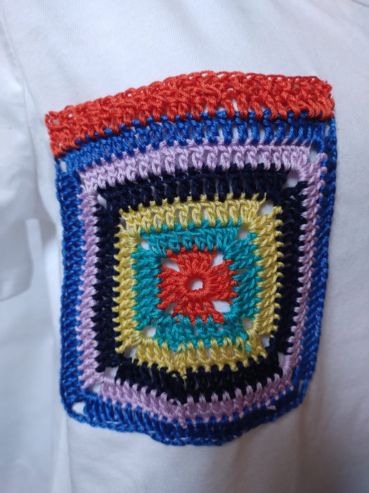 Lillo taschino ( Cod. Art. Rem 1990428 ). Applicato su maglietta. Realizzato in cotone. Tecnica uncinetto, piastrella " America ". Multicolore. Gr.8. Cm.10x10.