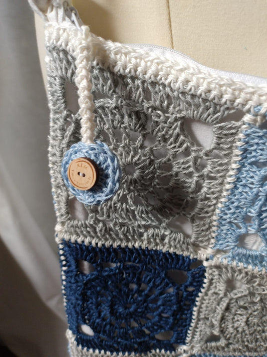 Dettaglio del motivo con piastrelle rotonde e quadrate sulla borsa Lin