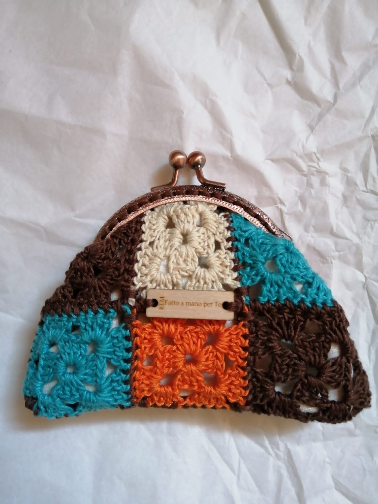 Porta un tocco di colore nella tua giornata con 'Piero', il nostro portamonete all'uncinetto. Realizzato a mano in cotone e dotato di una pratica chiusura clik clak, è il compagno perfetto per ogni avventura.