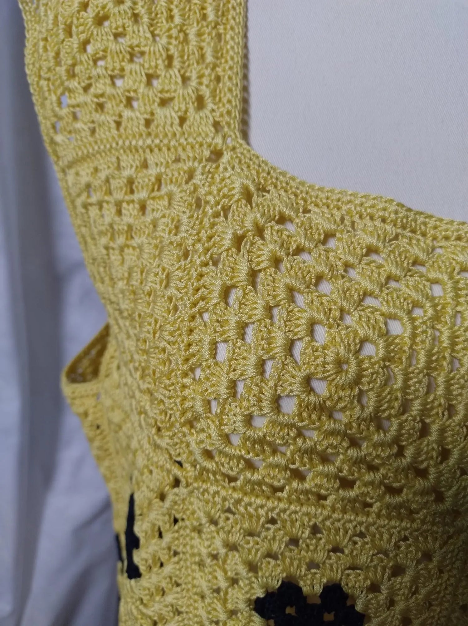 Scopri Iris la Canotta, realizzata in cotone con piastrella "Nonna" all'uncinetto. Ampia vestibilità, scollo quadrato e spacchi sui fianchi per un look estivo elegante. Acquista ora!