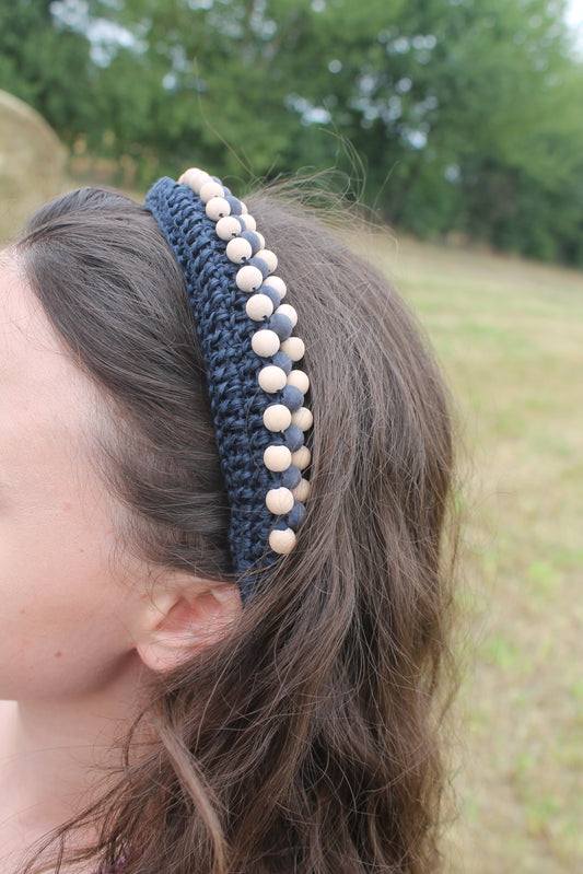 Scopri il nostro cerchietto elastico all'uncinetto, impreziosito da una decorazione in legno. Perfetto per un look naturale e comodo, realizzato a mano per un tocco unico.