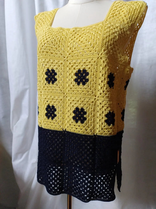Scopri Iris la Canotta, realizzata in cotone con piastrella "Nonna" all'uncinetto. Ampia vestibilità, scollo quadrato e spacchi sui fianchi per un look estivo elegante. Acquista ora!